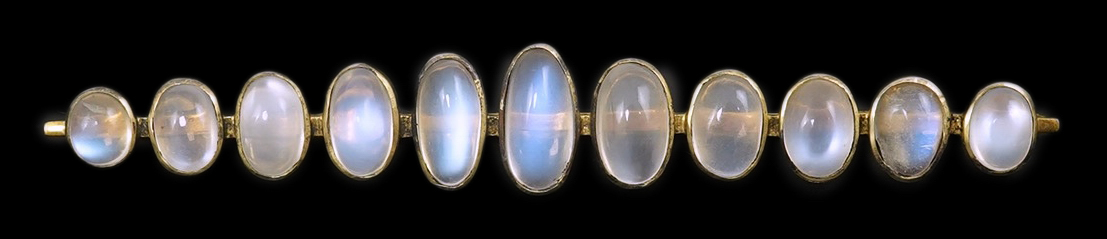 A gold and eleven stone graduated cabochon moonstone set bar brooch